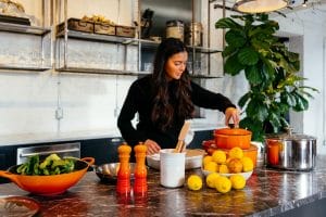 woman cooking healthy food with lemon and greens to improve mental health