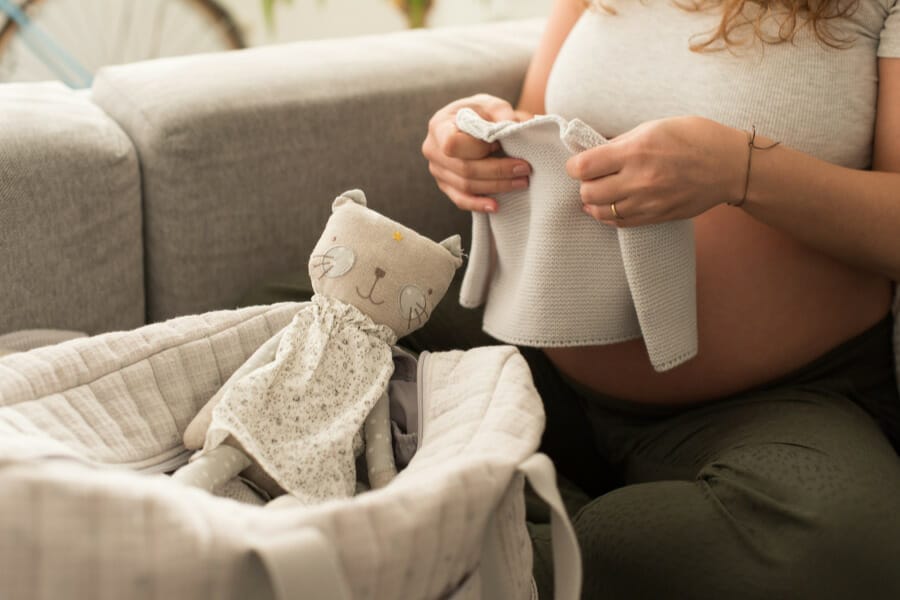 pregnant mom folding baby clothes