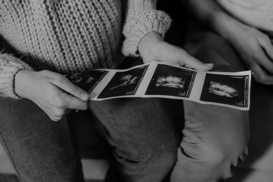 mom holding sonogram doing fertility positive affirmations