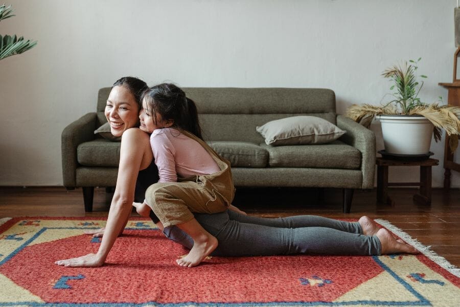 mom showing daughter healthy coping skills for children by practicing yoga and meditation