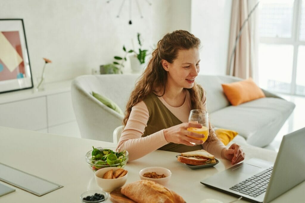 woman eating healthy breakfast during a Telehealth appointment
