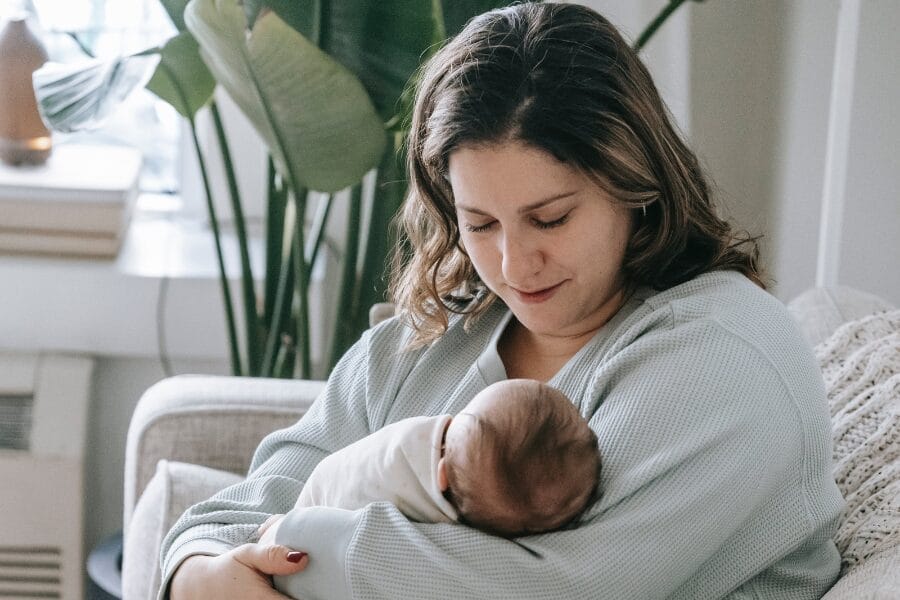 tired new mom holding her baby