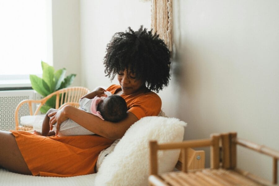 mom holding newborn before work