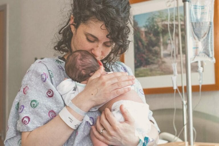 mom in hospital gown holding newborn