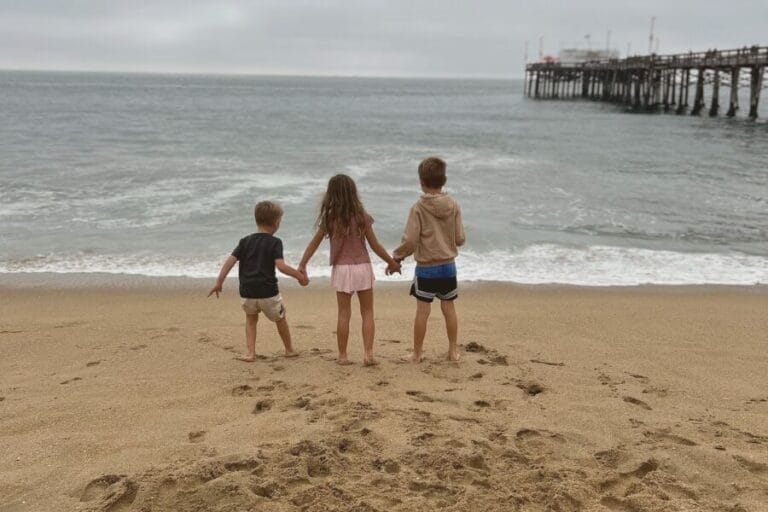 three kids looking at the ocean